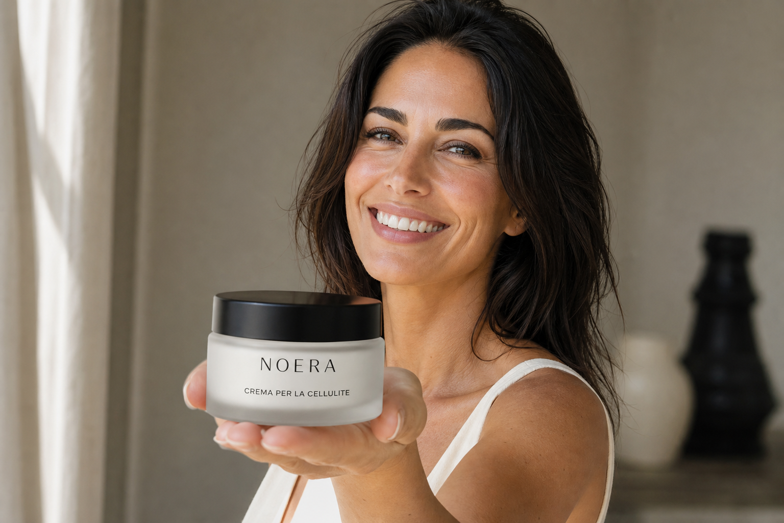 Donna che sorride tenendo in mano la crema corpo Noera